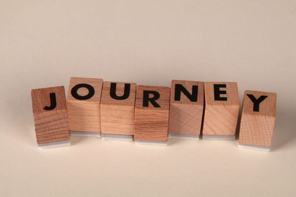Wooden blocks arranged to spell 'Journey' on a table, symbolizing adventure or progress.